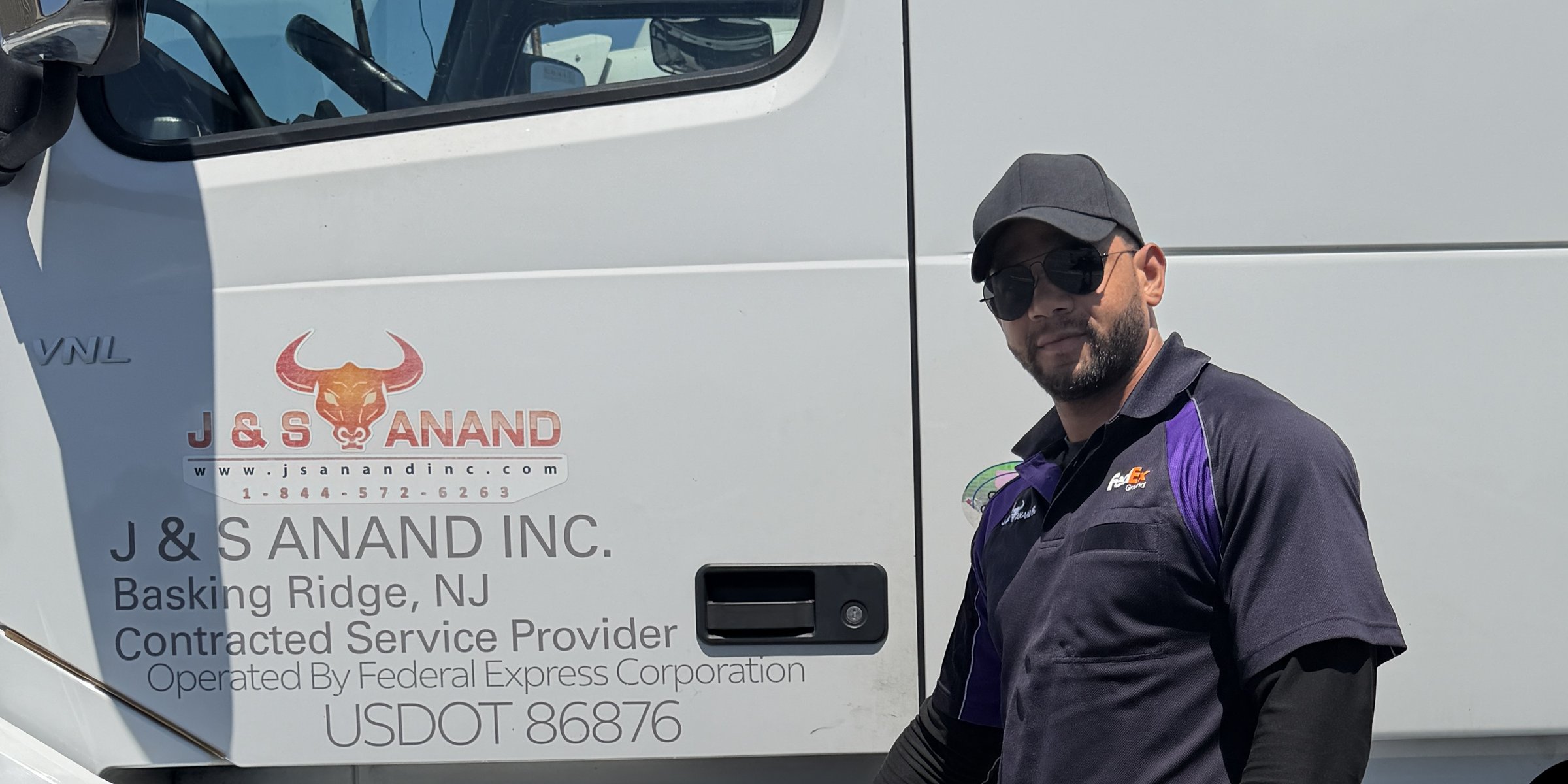 J&S Anand CDL-A driver beside a company tractor with Operated By Federal Express Corporation USDOT 86876 door branding