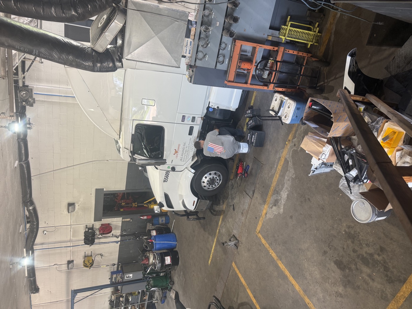 J&S Anand tractor in the service bay with a mechanic at work